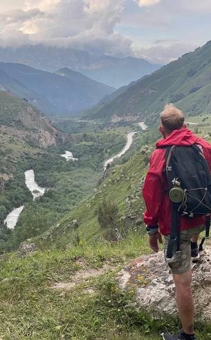 Hiker with a backpack looking over a mountain valley