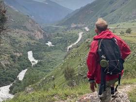 Hiker with a backpack looking over a mountain valley